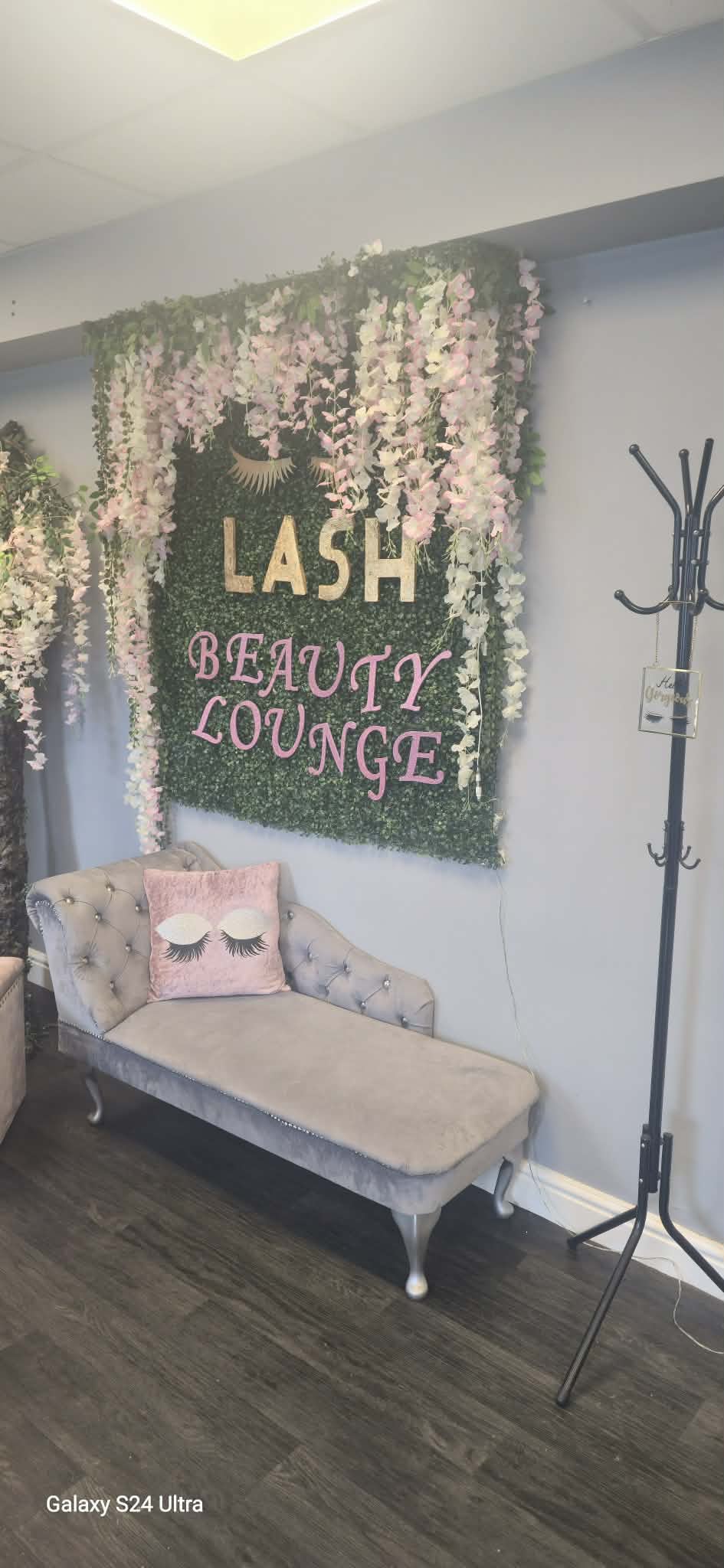 Beauty lounge seating beneath pink floral salon decor