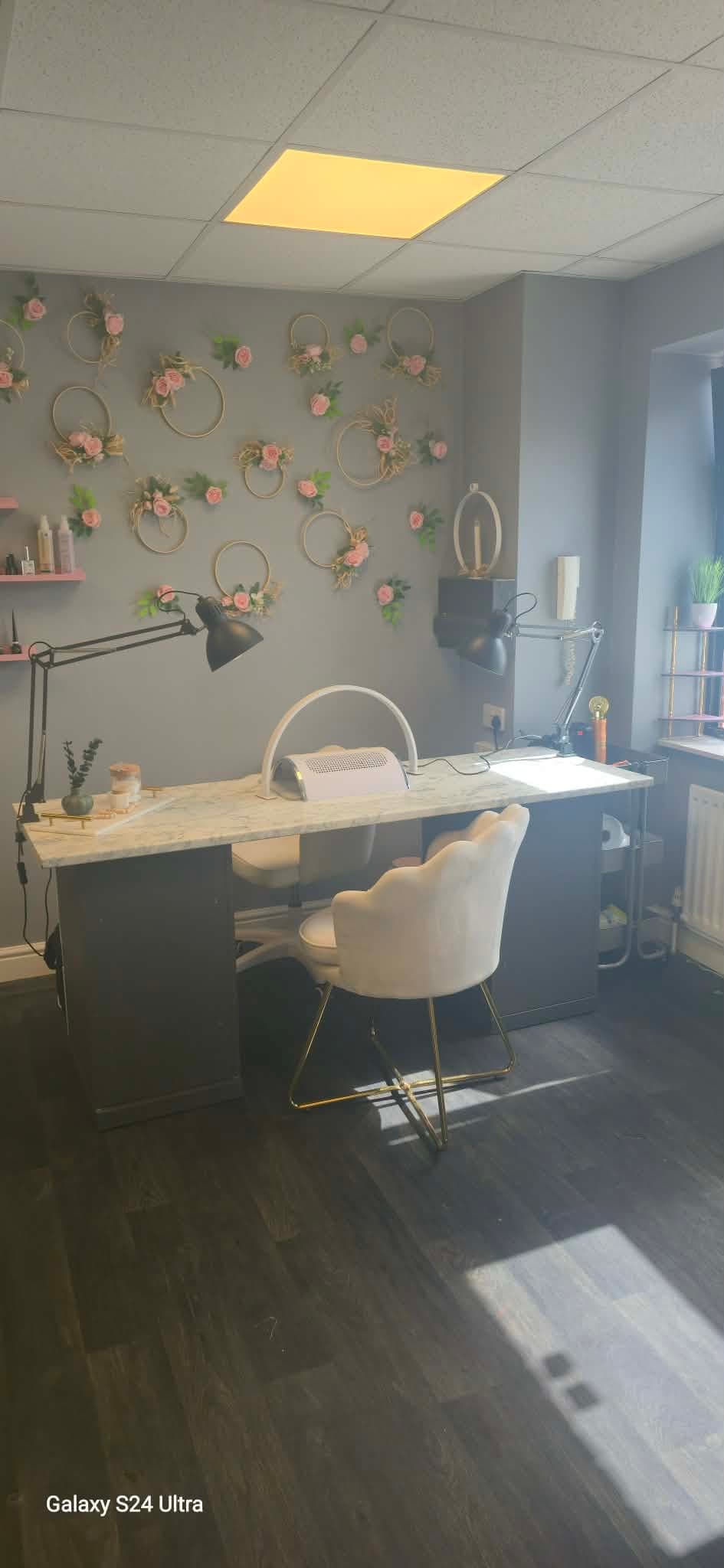 Double nail station with floral wall decorations inside the salon